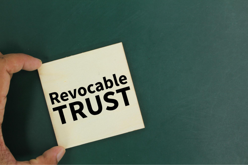 Hand holding revocable trust card.