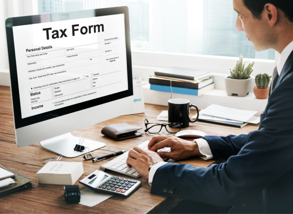 A professional sitting at a desk, using a computer to fill out a tax form, illustrating the process of handling estate tax paperwork.